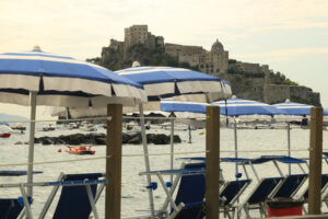 Umbrellas and deckchairs on the beach of Ischia Porto. Foto Ischia photos.