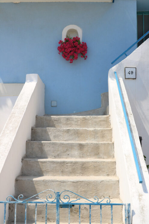 Vase of red flowers. Vase of red flowers on Mediterranean house facade. Staircase wit - MyVideoimage.com | Foto stock & Video footage