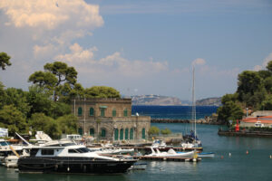 Village of  Ischia Porto with its typical Mediterranean houses. In the foreground the sea with some boats. - MyVideoimage.com