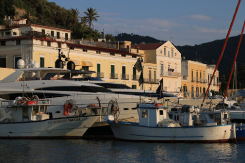 Village of  Ischia Porto with its typical Mediterranean houses. In the foreground the sea with some boats. - MyVideoimage.com