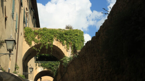 Walls with arches connected to the houses of Castiglione della Pescaia. An ancient village in the Tuscan Maremma built on a hill facing the sea. - MyVideoimage.com