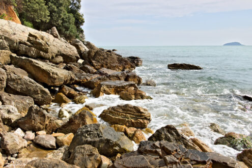 Waves of the sea break on the rocks. Mountain rocks of yellow color. and light-colored sea. - MyVideoimage.com