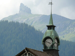 Wengen, Switzerland. Mountain and church with clock. - MyVideoimage.com