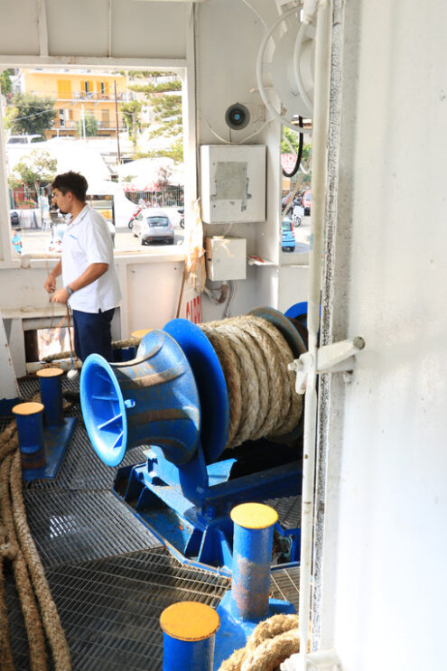 Winch of a ferry ship. A sailor maneuvering the mooring rope to - MyVideoimage.com