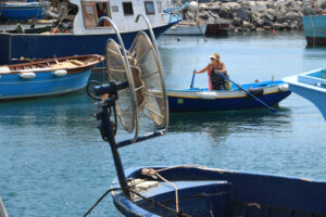 Woman on rowboat. Woman with rowing boat in the port of Corricella. - MyVideoimage.com | Foto stock & Video footage