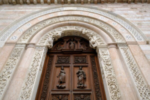 Wooden door Foligno, Italy. Wooden door and portal in light marble carved of the Cathedral of San Feliciano in Foligno. - MyVideoimage.com | Foto stock & Video footage