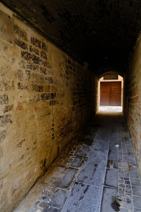 Wooden door at the end of a covered street, closed and dark. - MyVideoimage.com | Foto stock & Video footage