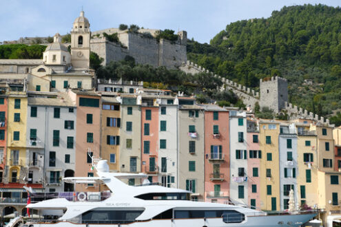 Yacht a Portovenere vicino alle Cinque Terre, con le tipiche case colorate. La chiesa, le torri delle mura e il porto con barche e yacht. - MyVideoimage.com | Foto stock & Video footage