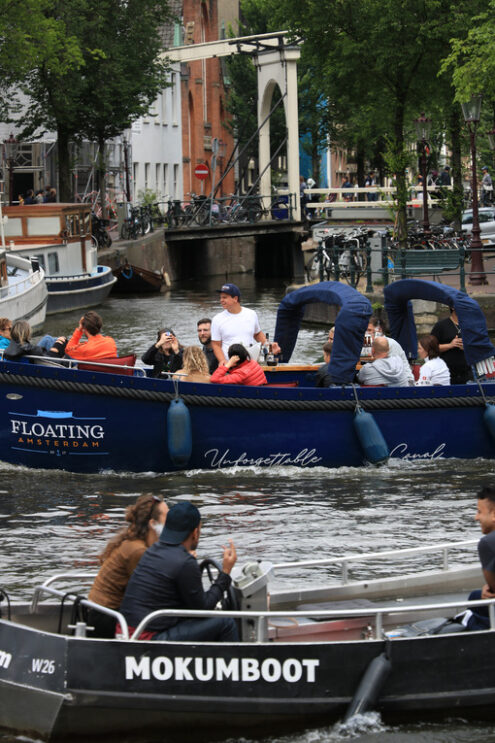 Young people on a tourist trip on a boat in the city canals. - MyVideoimage.com